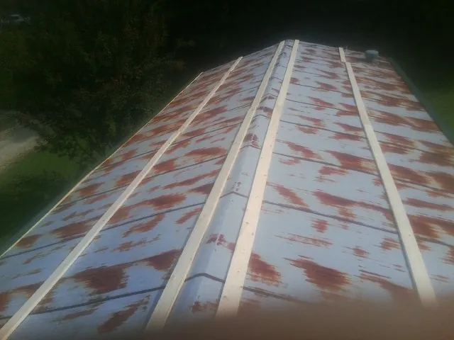 Rusted metal roof panels with new wood purlins before replacement — Storm Damage Roof Repair in Gulf Shores by Roofing Brothers