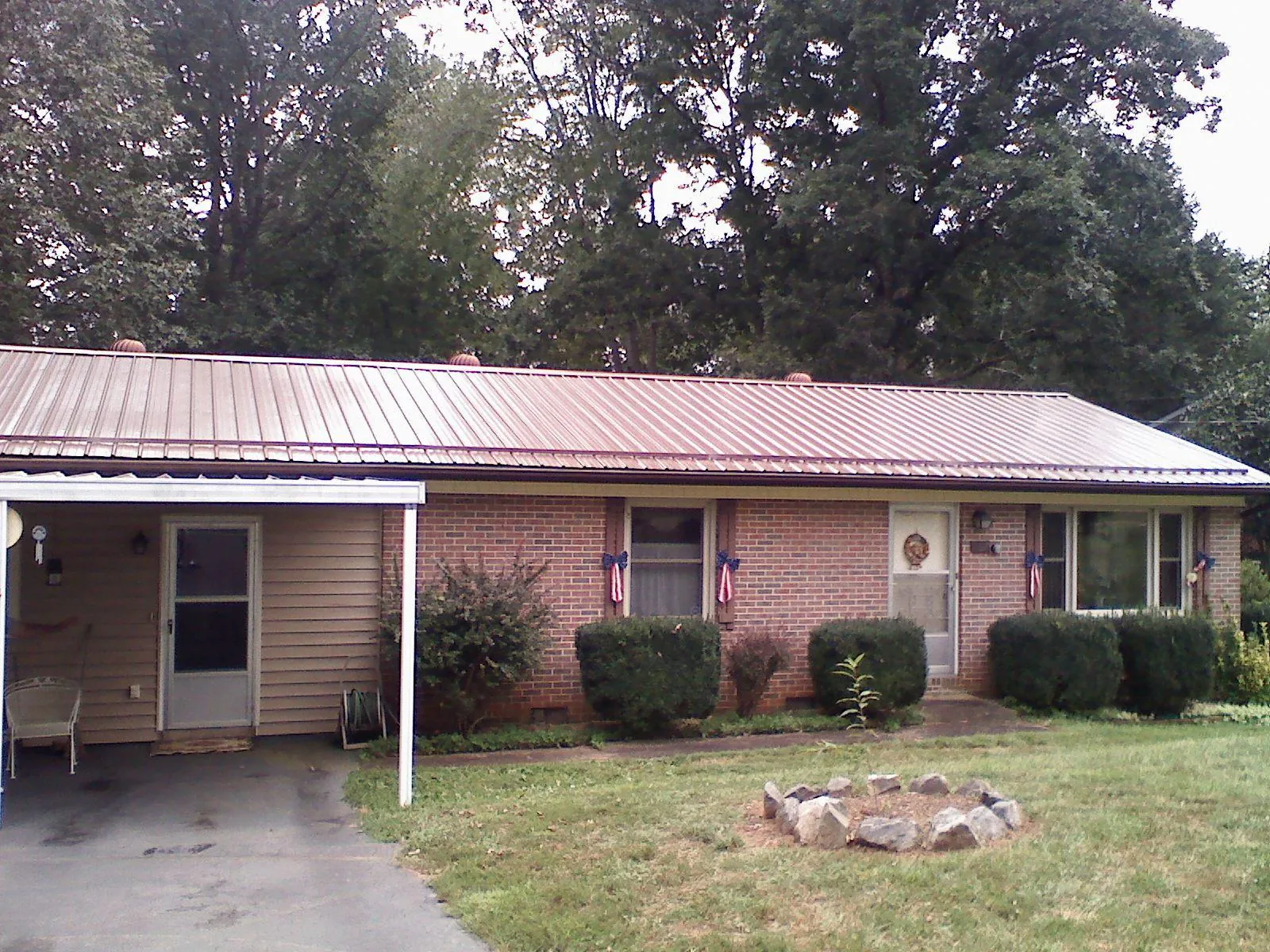 Bronze metal roof and carport on a brick ranch home — Roof Repair work by our crew in Gulf Shores