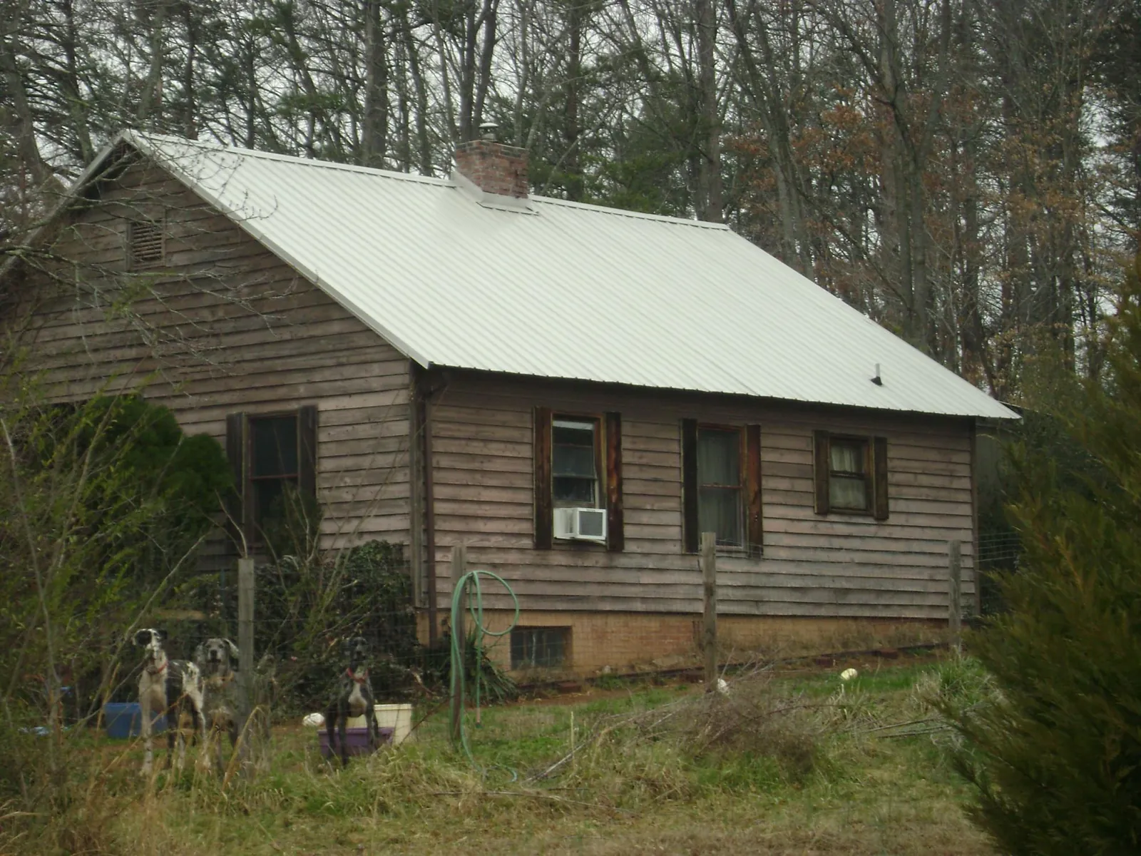 White metal roof on an old wood sided farmhouse, from a Metal Roof Installation job in Gulf Shores